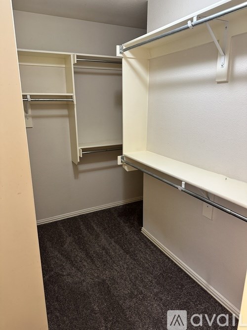 A small, empty room with a carpeted floor and white walls.