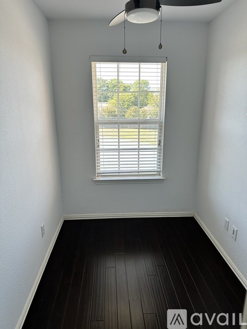 A room with a window and wooden floors.