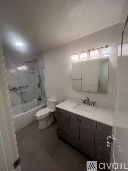 A bathroom with a toilet, sink, and mirror.