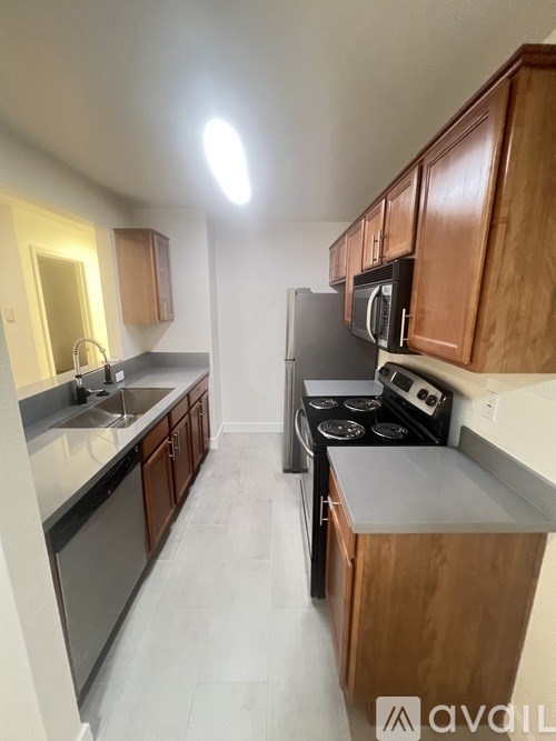 A kitchen with wooden cabinets and a black stove top oven.