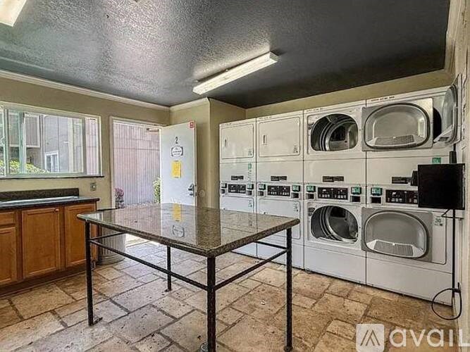 A laundry room with a table and washing machines.