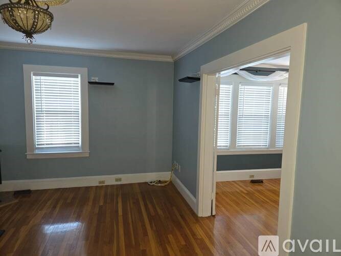 A room with wooden floors and a chandelier.