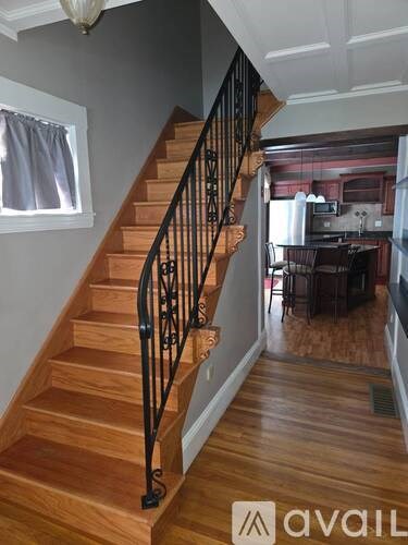A staircase with wooden steps and black metal railings.