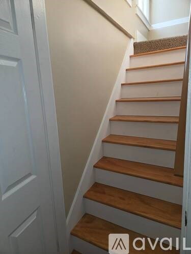 A staircase with white walls and wooden steps.