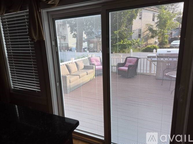 A patio with a couch and chairs is visible through a window.