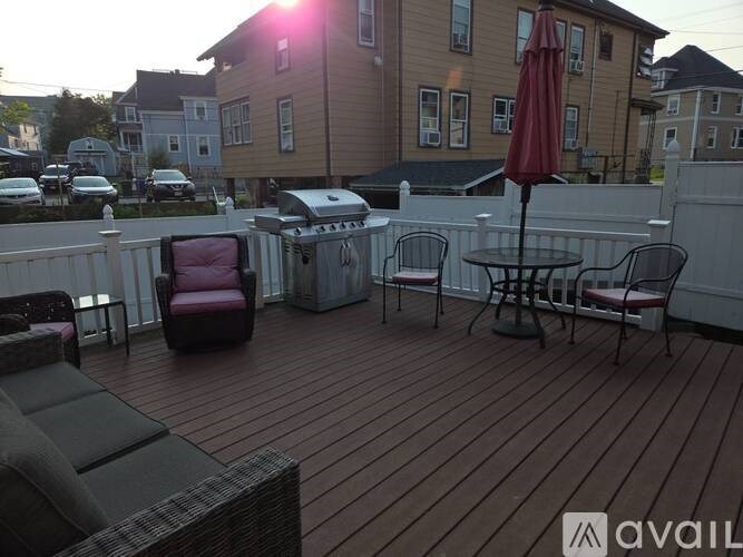 A patio with a table, chairs, and an umbrella.