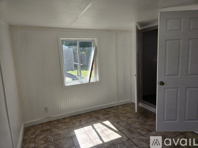 A room with a window and a door is available for rent.