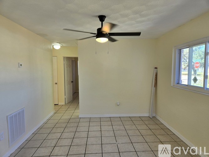 A room with a ceiling fan and tiled floor.