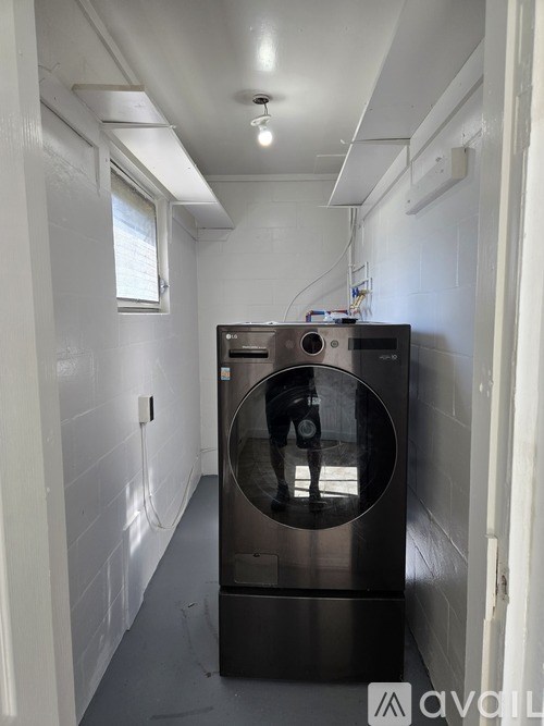 A person is standing inside a large, dark-colored oven in a narrow hallway.