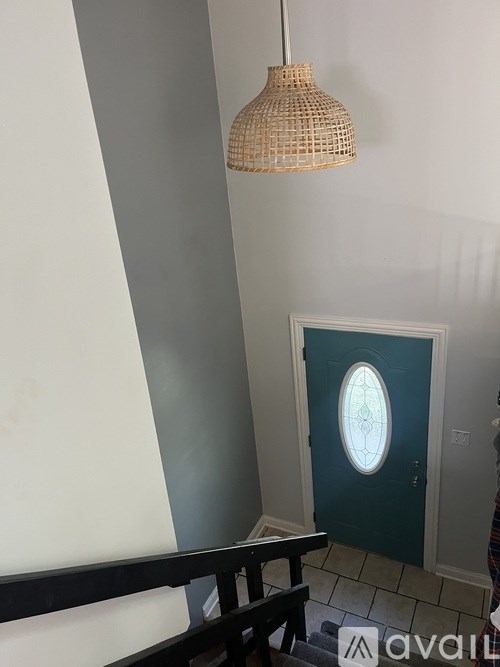 A door with a window in the middle is set in a white wall.