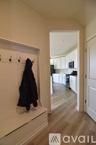 A black coat is hanging on a white coat rack.