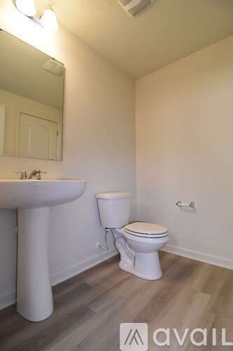 A white toilet sits next to a sink in a small bathroom.