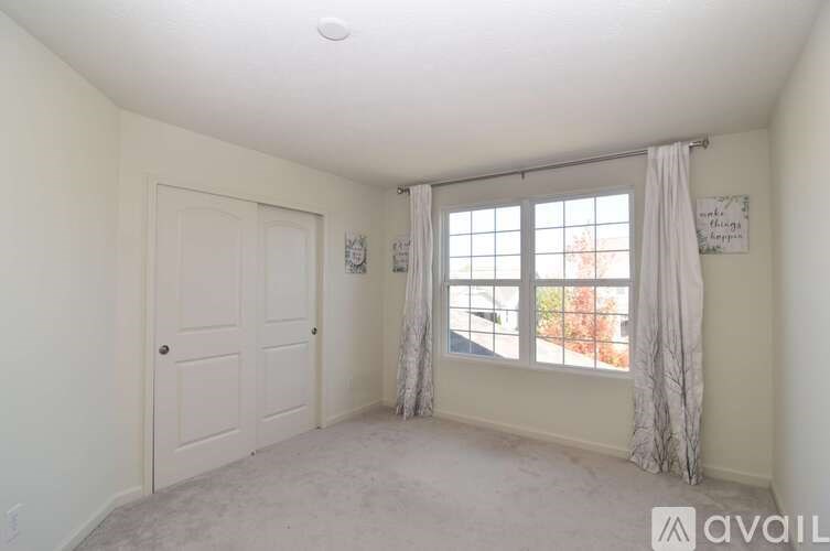 A room with a window and a door is available for rent.
