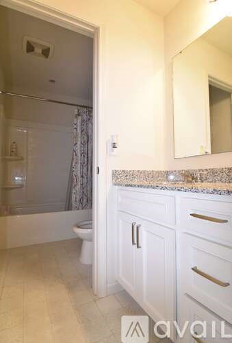 A bathroom with a toilet, sink, and mirror.