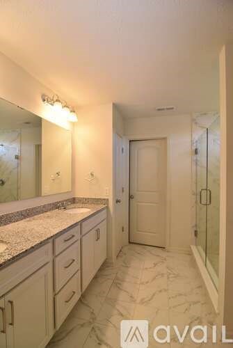 A bathroom with a marble counter top and a large mirror.