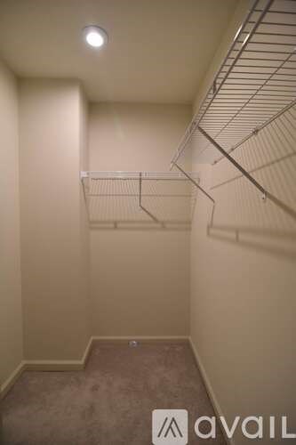A small, empty room with a carpeted floor and a metal shelving unit.