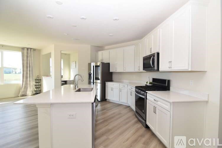 A modern kitchen with white cabinets and appliances.