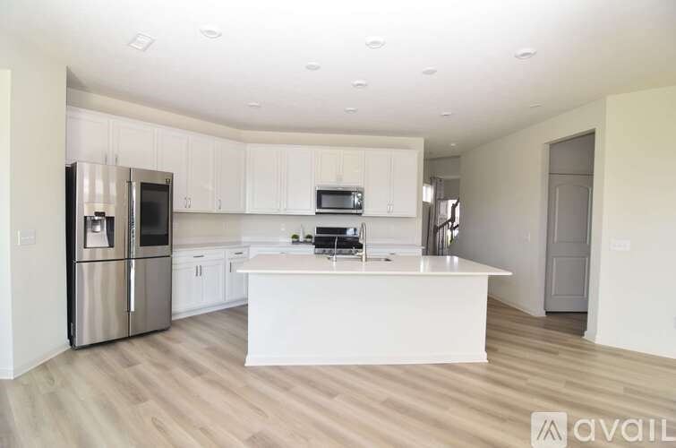 A modern kitchen with stainless steel appliances and white cabinetry.