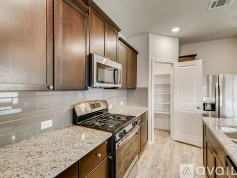 A kitchen with wooden cabinets and a granite countertop.