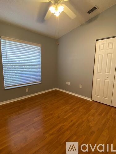 A room with wooden flooring and a ceiling fan.