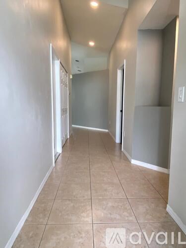 A long hallway with tiled floors and white walls.