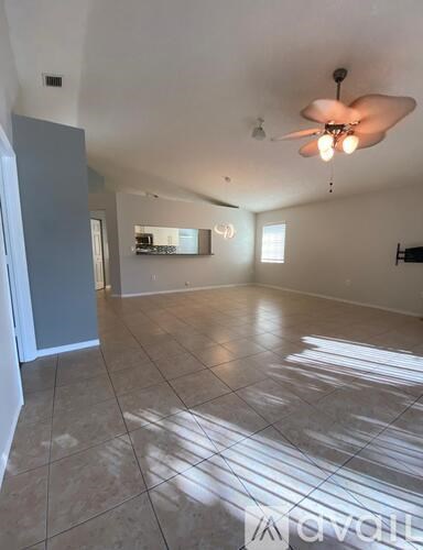 A spacious room with a ceiling fan and tiled flooring.
