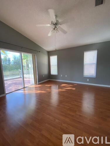 A room with wooden floors and a ceiling fan.