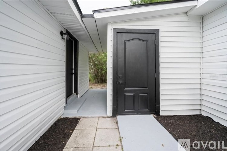 A black door is on the right side of a white wall.