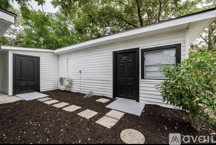 A small white house with a black door and window.