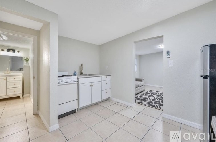A kitchen with white cabinets and a black fridge.