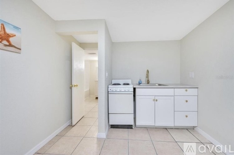 A kitchen with white appliances and cabinets.