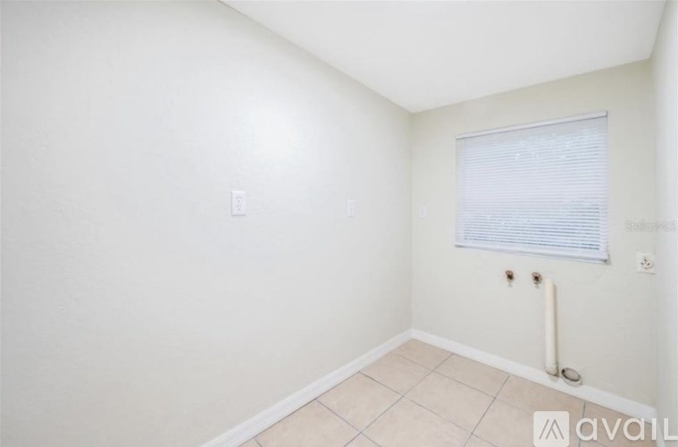 A room with a window covered by blinds and a radiator on the wall.