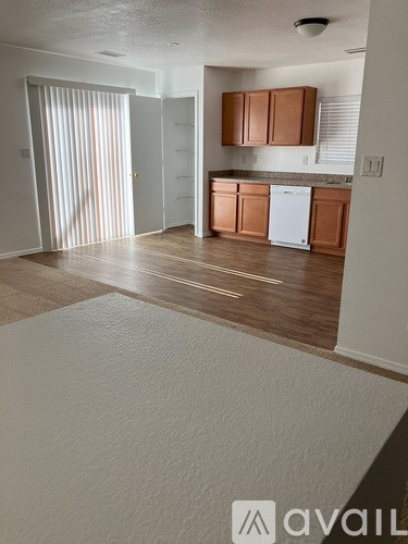 A kitchen area with wooden floors and white appliances.