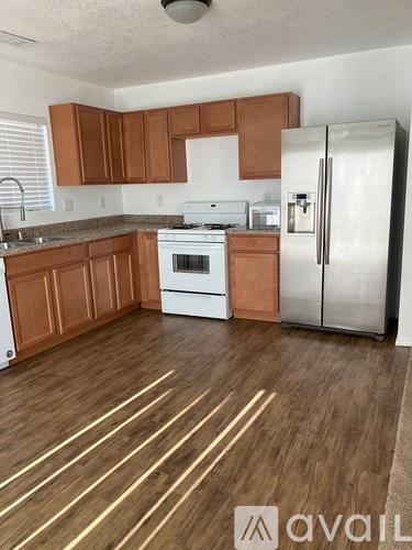 A kitchen with wooden floors and white appliances.