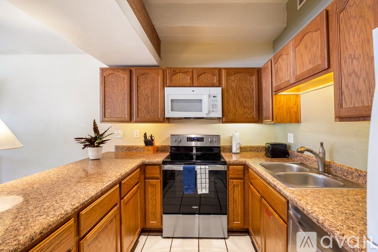 A kitchen with wooden cabinets and granite countertops.