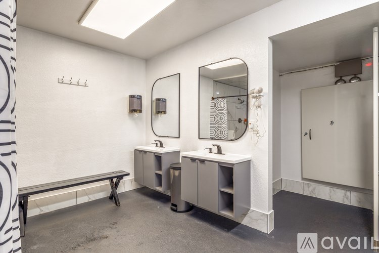 A bathroom with a mirror, sink, and a bench.