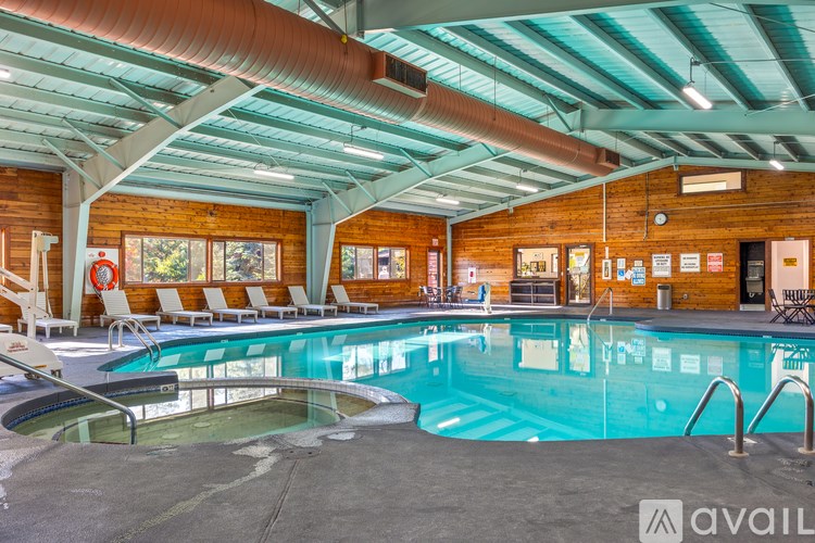 A large indoor swimming pool with a wooden wall and ceiling.