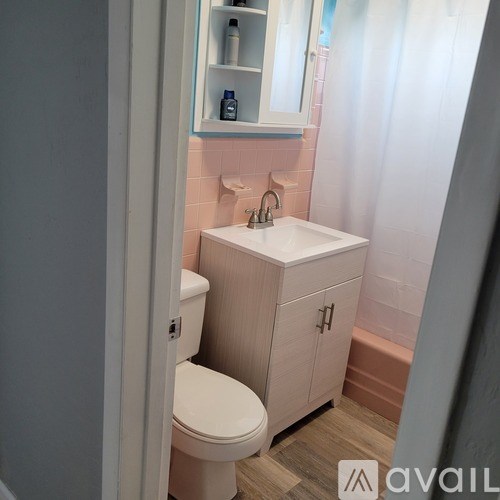 A bathroom with a toilet, sink, and a cabinet.