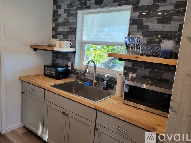 A kitchen with a sink, toaster, and a window.