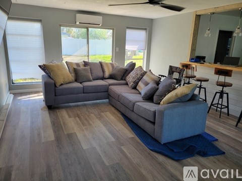 A living room with a grey couch and a wooden floor.