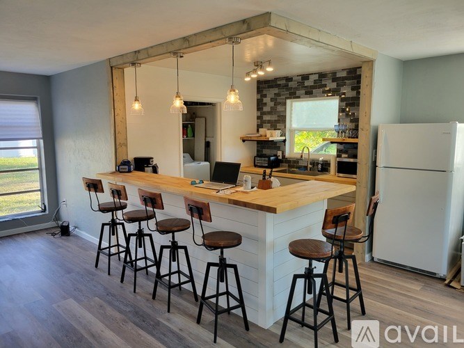 A kitchen with a bar area and a refrigerator.