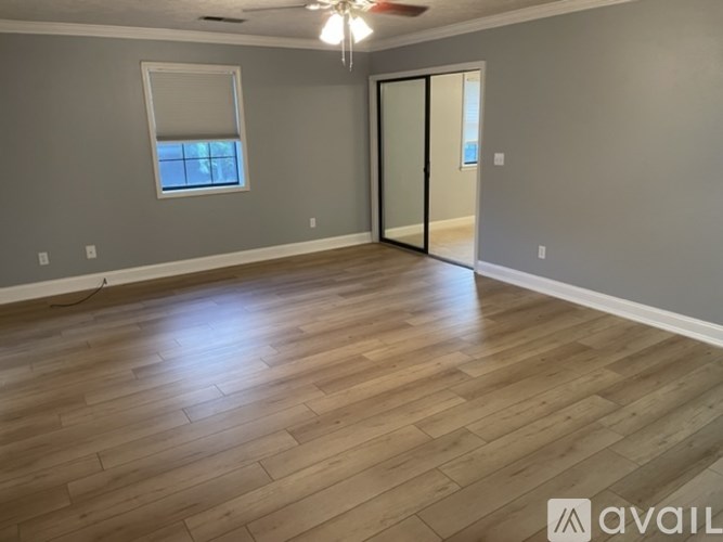 A room with wooden flooring and a ceiling fan.