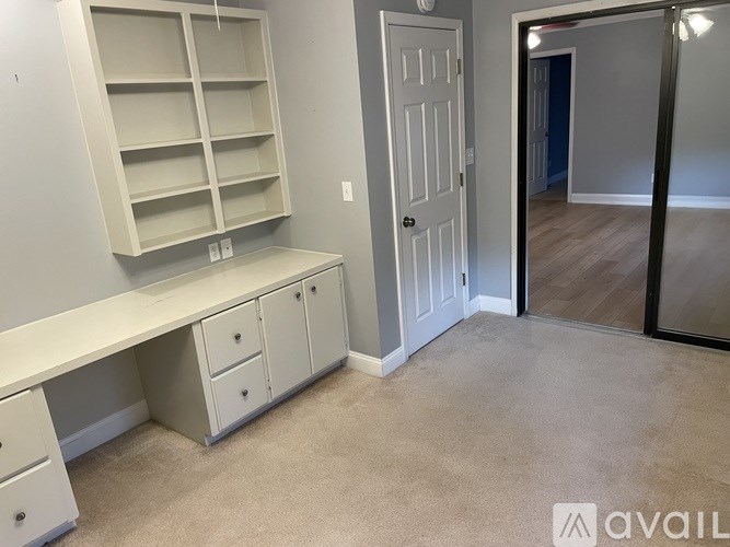 A room with a white desk and a white door.