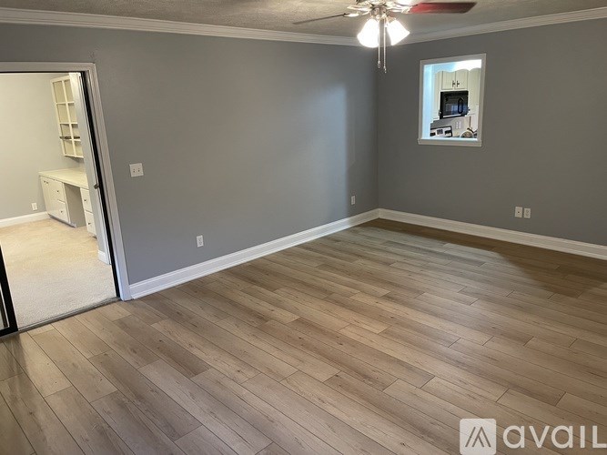 A room with wooden flooring and a ceiling fan.
