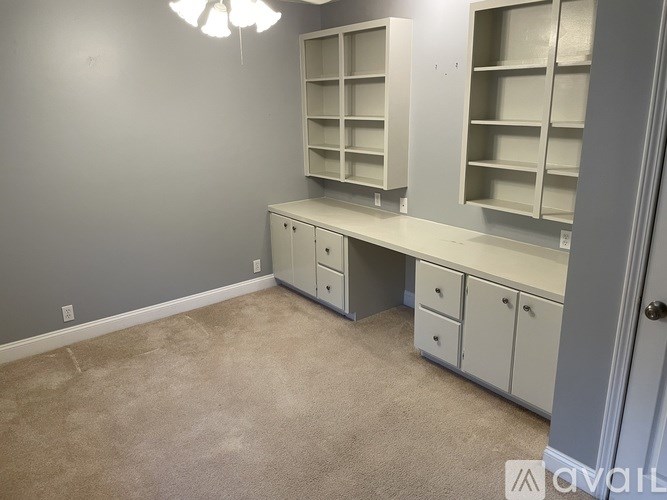 A room with a desk and shelves in it.