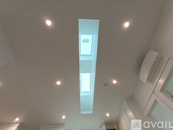 A modern kitchen with a skylight and recessed lighting.
