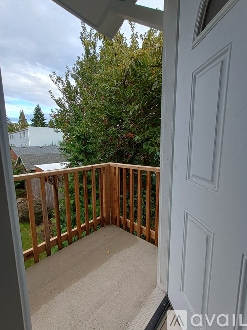 A balcony with a view of a house and trees.