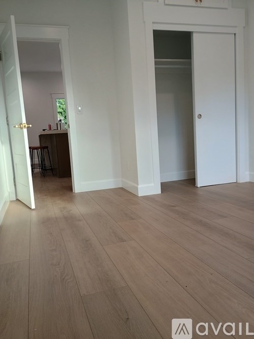 A room with wooden flooring and two white doors.