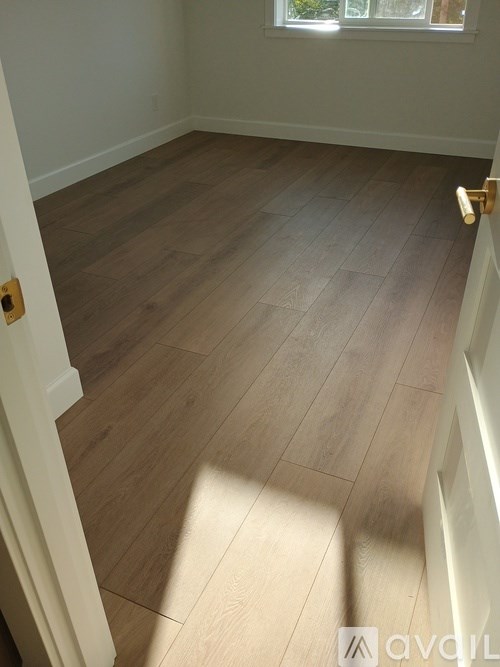 A room with wooden flooring and a white door.