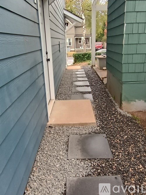 A gravel path with stepping stones and a wooden plank in the middle.